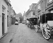 857982 Gezicht in de Keukenstraat te Utrecht, met twee koetsjes van stalhouderij Schoonhoven-Buytendijk (Nieuwegracht 68).